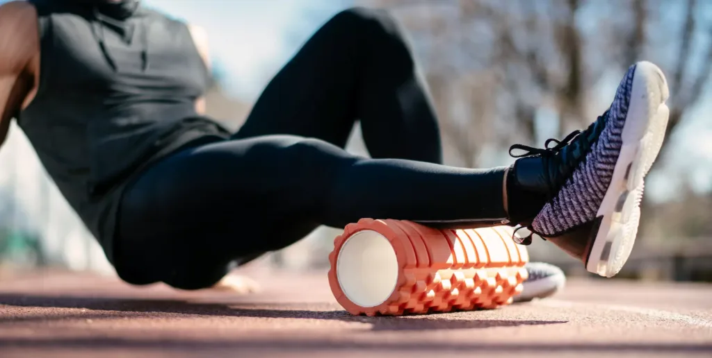 Man foam rolling. Athlete stretches using foam roller.